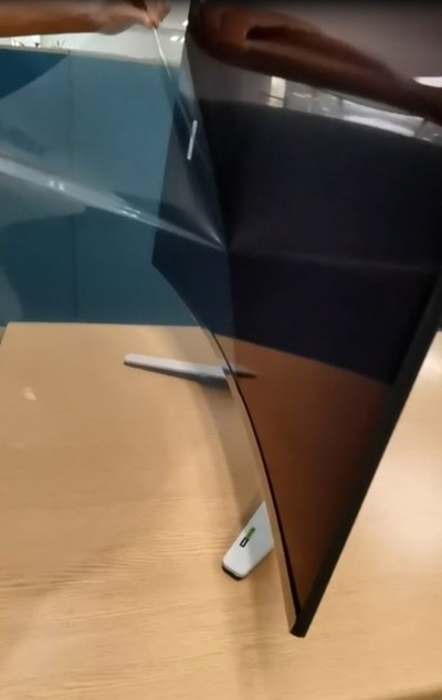 Peeling the film of the screen of an Alienware curved OLED monitor