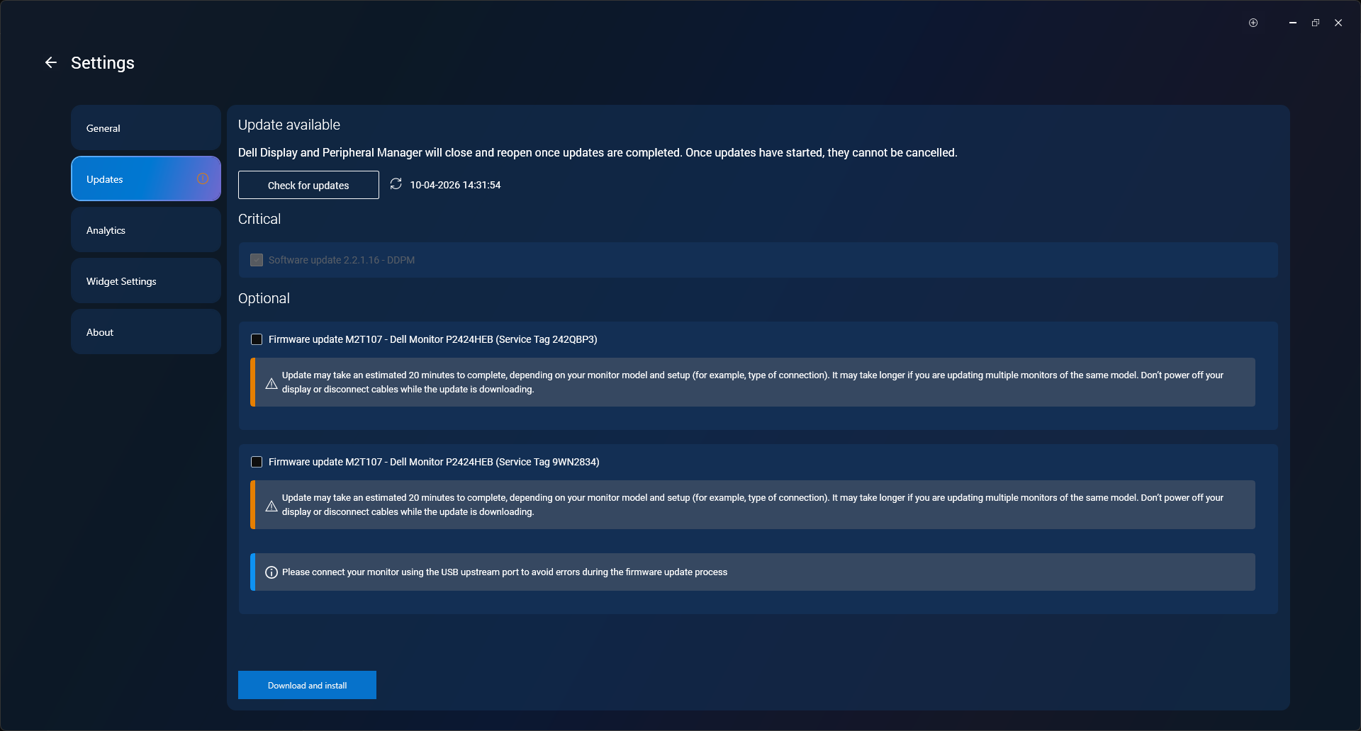 Dell Display och Peripheral Manager som visar uppdatering av fast programvara tillgänglig för två anslutna Dell-skärmar med knappen Ladda ner och installera