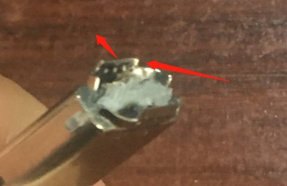 Conector USB-C roto con carcasa rasgada y cables expuestos debido a un manejo brusco